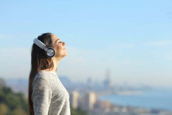 Frau entspannt in der Natur und hört Musik