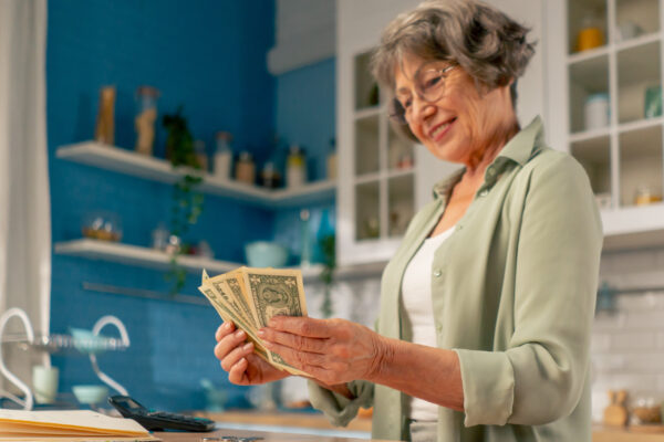 Eine Frau steht in der Küche und zählt Geld